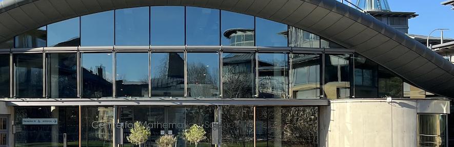 CMS front reflecting buildings on site with a blue sky